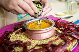 curry powder in bowl surrounded by dried chillies.